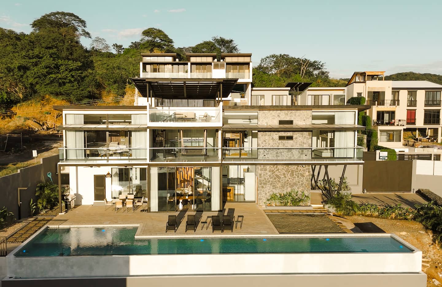 Front of the house at sunset with the 25-yard infinity pool in the foreground, above Tamarindo bay